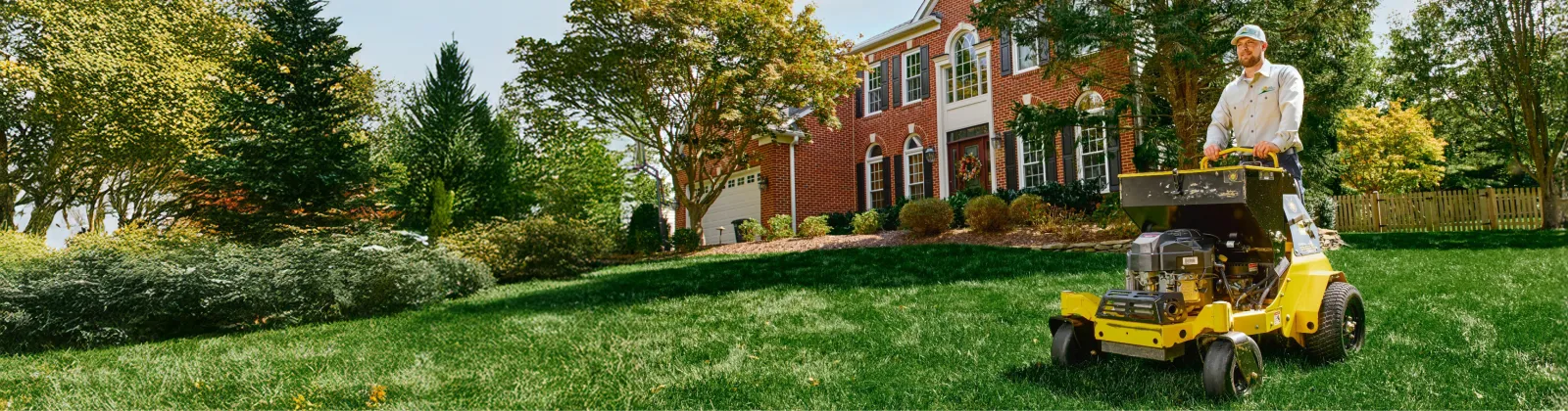 Lawn care technician overseeding lawn after aeration - Lawn Aeration & Seeding near me